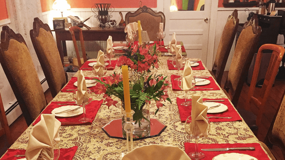 A beautifully set dining table with floral centerpieces and elegant tableware in a warmly lit room.