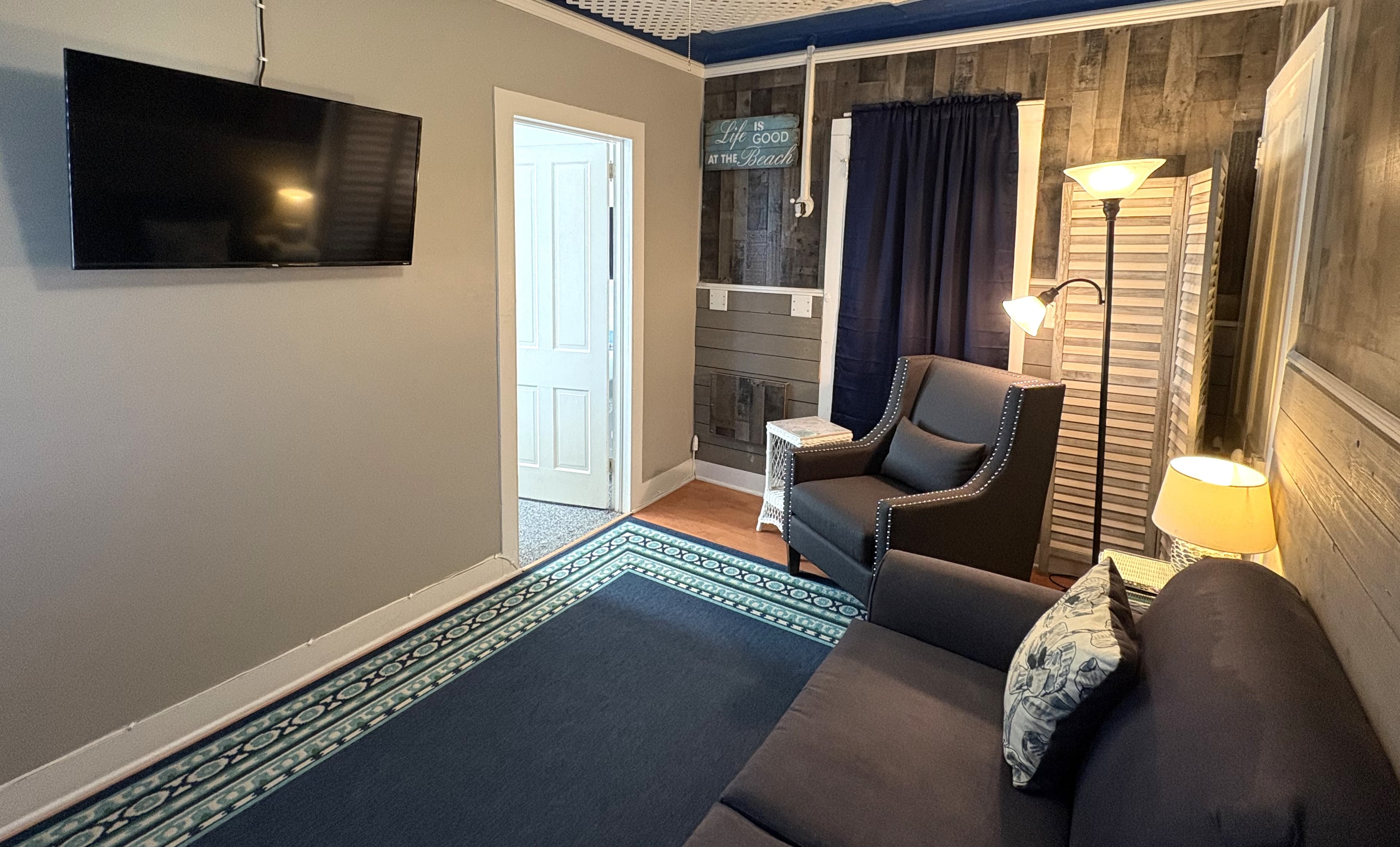 A cozy living space featuring a television, a comfortable chair, and decorative lighting.